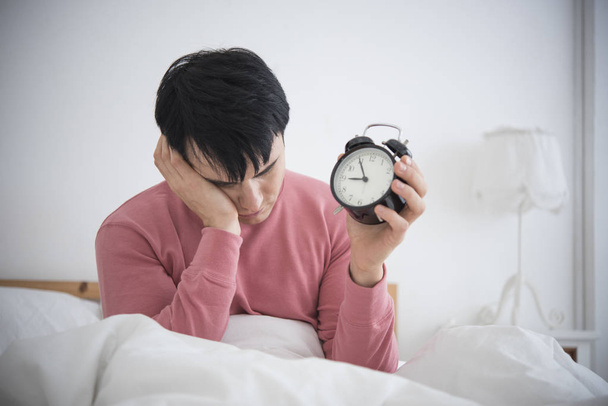 Man wake up doing turn off alarm clock in the morning.  - Foto, Imagen