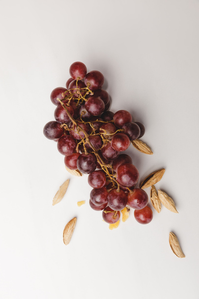 Vue de dessus des raisins et des amandes sur blanc
 - Photo, image