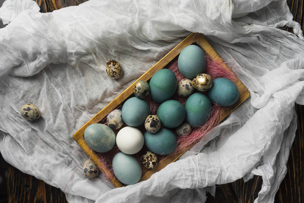Blue, and white and chicken eggs and quail eggs in wooden retro  - Foto, afbeelding