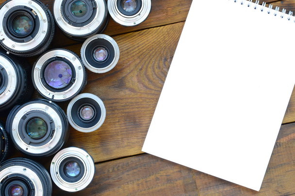 Birkaç fotoğraf lensler ve beyaz dizüstü bir kahverengi ahşap arka plan üzerinde yalan. Metin için yer - Fotoğraf, Görsel