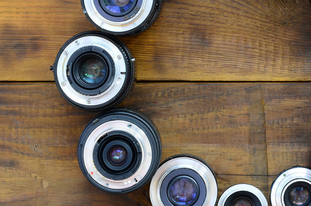 Birkaç fotoğraf lensler bir kahverengi ahşap arka plan üzerinde yalan. Metin için yer - Fotoğraf, Görsel