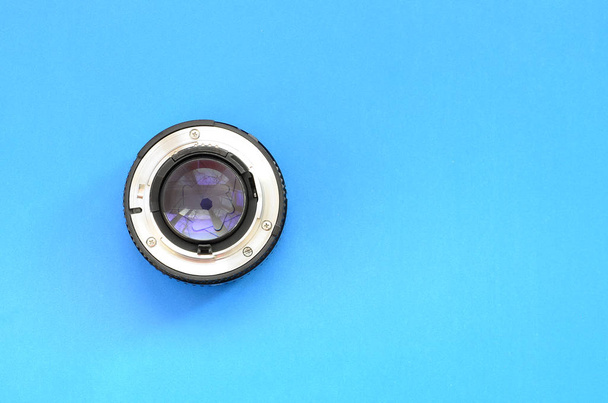 Una lente fotográfica se encuentra sobre un fondo azul brillante. Espacio para texto
 - Foto, Imagen