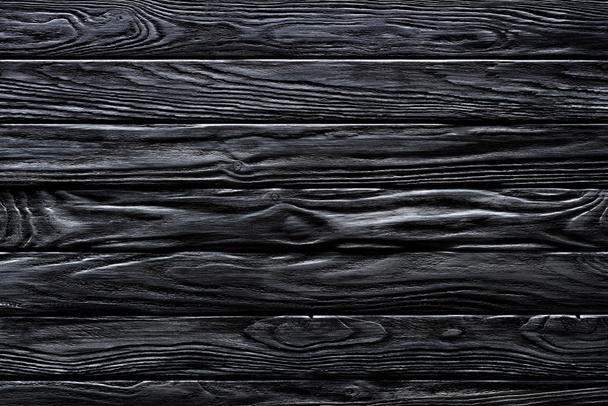 Wooden horizontal planks painted in black background - Foto, immagini