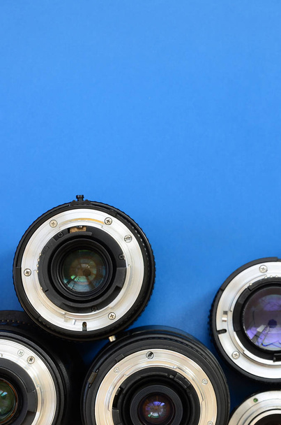 Varios lentes fotográficos se encuentran sobre un fondo azul brillante. Espacio para texto
 - Foto, Imagen