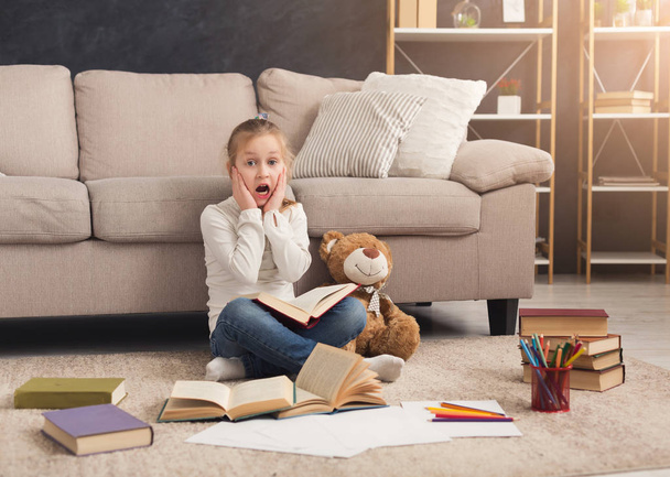 Petite fille avec livre et son jouet préféré à la maison
 - Photo, image