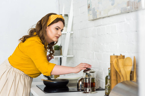 вид збоку красивої жінки, що готує на кухні
 - Фото, зображення