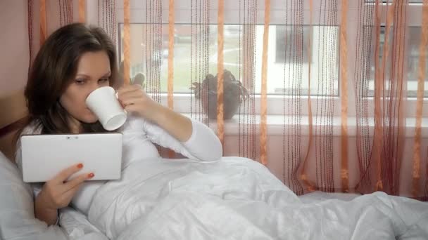 Ustaraná manželka čtení špatné zprávy v tabletu počítač a pít ráno kávu čaj - Záběry, video