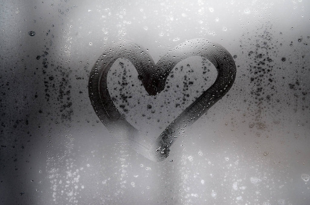 Corazón está pintado en el vidrio nebulizado en el invierno
 - Foto, imagen