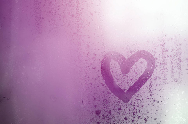 Corazón está pintado en el vidrio nebulizado en el invierno
 - Foto, Imagen