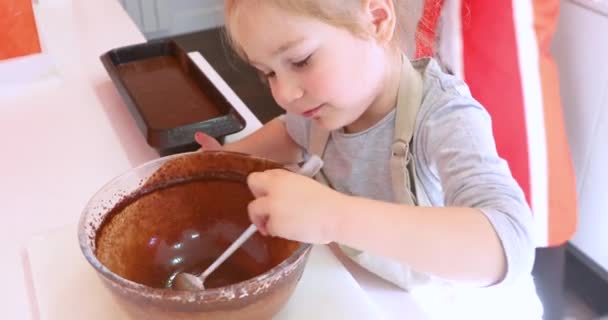 faim quatre ans fille manger du chocolat ou de la crème de cacao avec cuillère de bol en verre, à la cuisine de la maison, à côté de sa mère
 - Séquence, vidéo