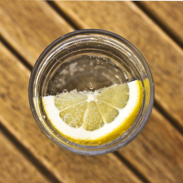 Água gaseificada carbonatada com limão em um copo com bolhas em um br
 - Foto, Imagem