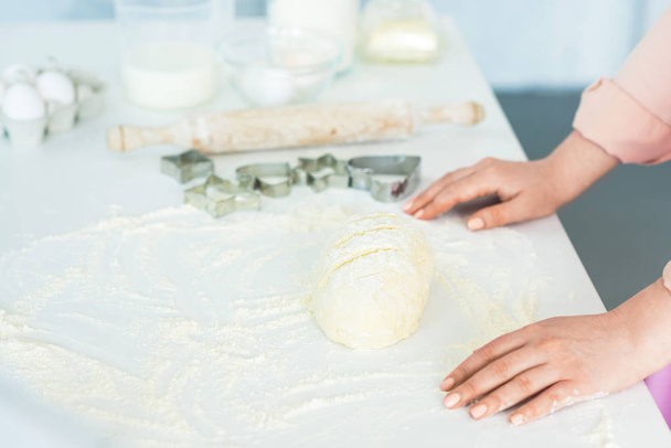 обрезанный образ женщины, стоящей рядом с тестом для выпечки хлеба на кухне
 - Фото, изображение