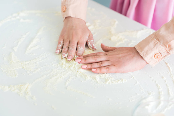 キッチン カウンター上に小麦粉を広がっている女性の画像をトリミング - 写真・画像