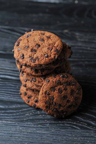 biscoitos de aveia com chocolate em um fundo de madeira escura
 - Foto, Imagem