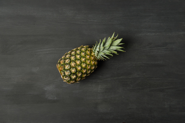 top view of fresh ripe pineapple on dark tabletop - Photo, Image