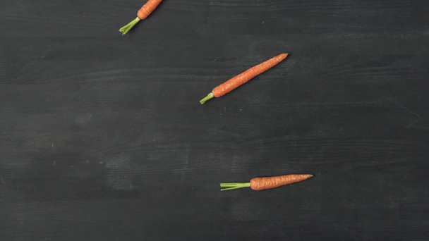 stop motion footage with ripe carrots on dark surface - Footage, Video