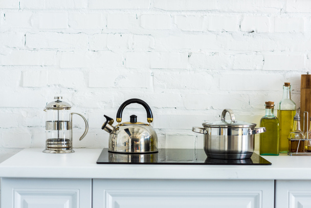 kettle and pan on electric stove in kitchen - Valokuva, kuva