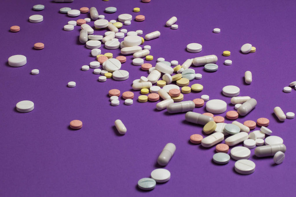 Tablets scattered on a violet background. - Photo, image