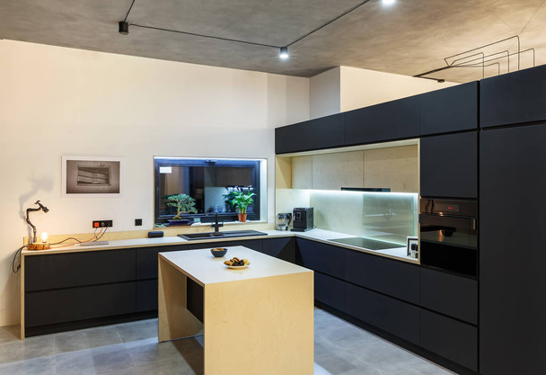 Wnętrze z przestronną kuchnię z czarnym fasady w loft st - Zdjęcie, obraz