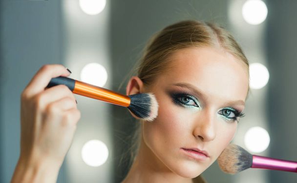 Visage model with makeup brushes. Visage course for glamour makeup. - Photo, Image