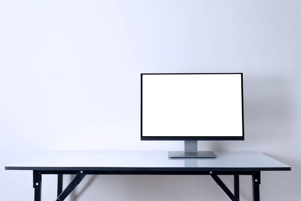 コンピューターのモニターの作業領域の背景の白いテーブルに - 写真・画像