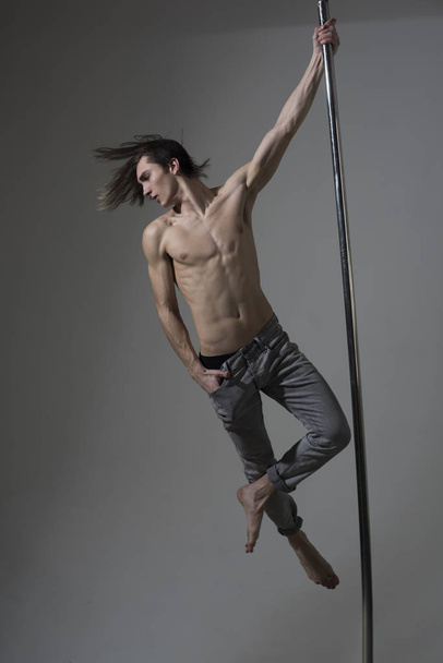 Guy makes figure on pole, fly in air. - Photo, Image