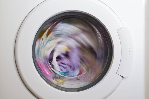 Puerta de la lavadora con prendas giratorias en el interior - Foto, Imagen