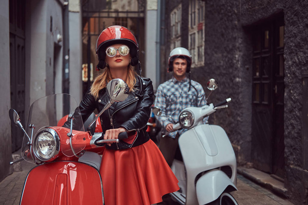 Красенем і сексуальний стильна дівчина прогулянки з ретро італійський скутери по старих вулицях міста. - Фото, зображення