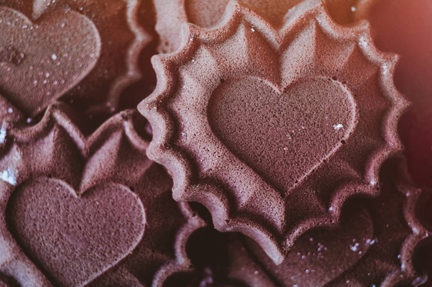 Las magdalenas de chocolate en forma de los corazones - la cocción fresca, el concepto de la declaración del amor, la tonificación
 - Foto, Imagen