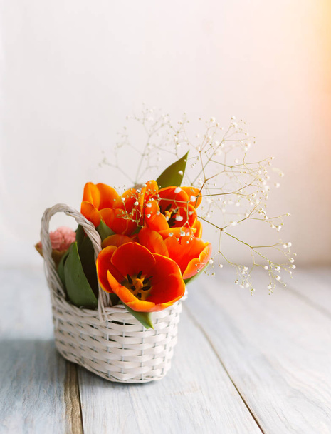 Tulips in a basket on a white wooden background - Foto, immagini