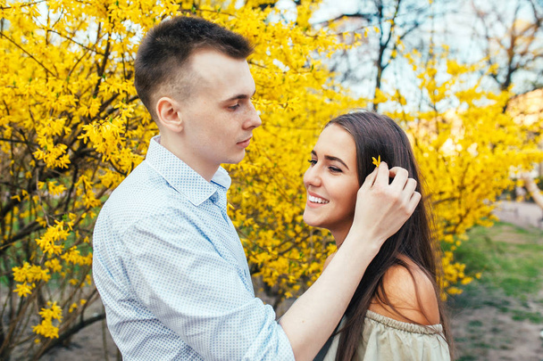 Young happy couple in love outdoors. Man and woman on a walk in a spring blooming park - Fotografie, Obrázek