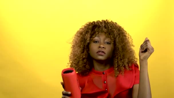 Girl of african american woman holding a player gadget and dancing .Yellow background - Filmagem, Vídeo