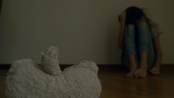 zdesperowany dziecko w depresji siedzi na ścianie swojego pokoju, stara się próby samobójcze. obok niego jest opuszczony Pluszak. 4k, zwolnionym tempie. - Materiał filmowy, wideo