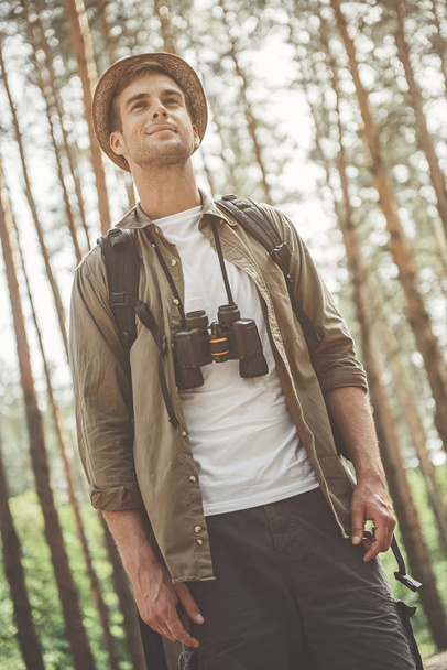 Positive pleasant hiker is spending time in wood - Фото, зображення