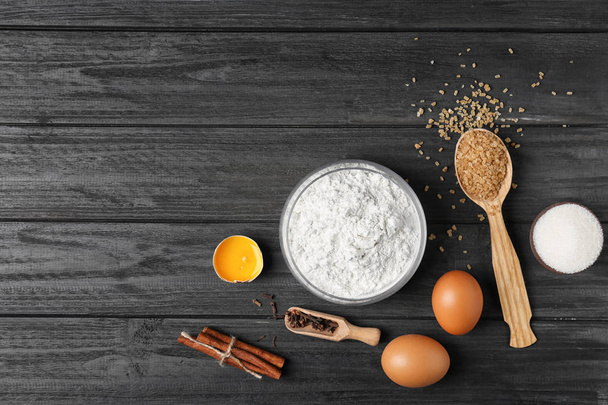 Composition with flour, eggs and sugar on wooden background, top view - Photo, Image