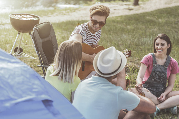 Cheerful friends organizing picnic with a song - Foto, Imagen