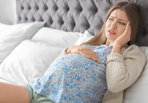 Young pregnant woman suffering from headache at home - Foto, Bild