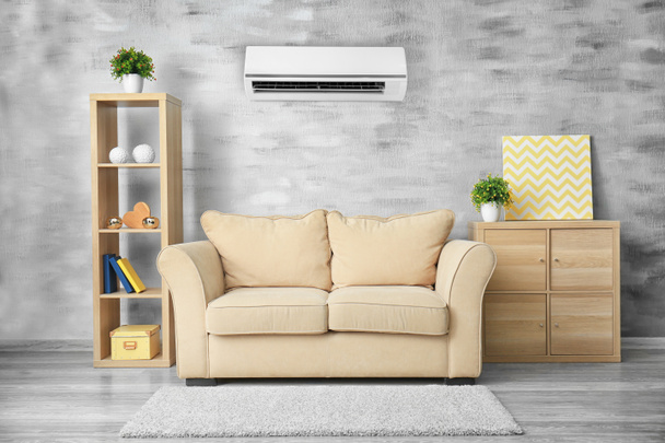 Wohnzimmereinrichtung mit bequemem Sofa und Klimaanlage - Foto, Bild