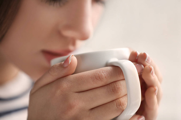 Beautiful young woman with cup of hot tea, closeup - Photo, Image