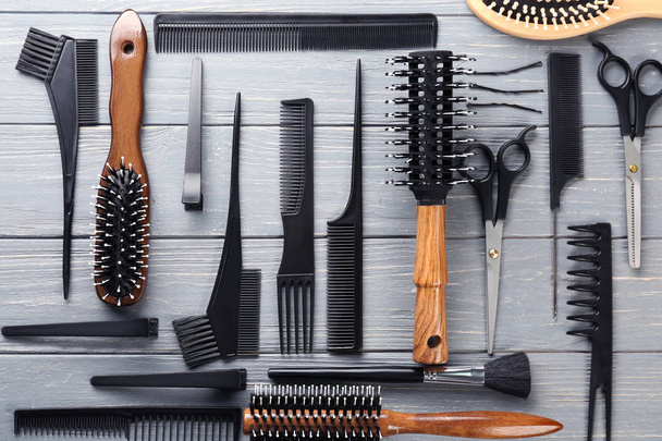 Flat lay composition with professional hairdresser's tools on wooden background - Photo, image