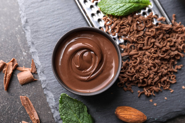 Вкус расплавленного и тертого шоколада на столе
 - Фото, изображение