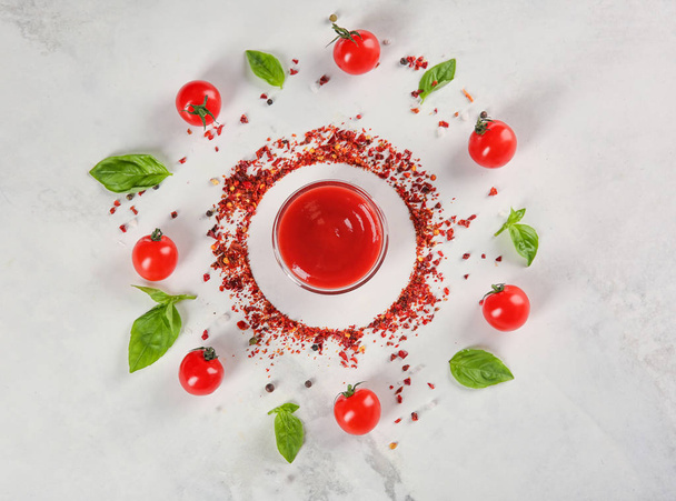 Επίπεδη lay σύνθεση με κόκκινη σάλτσα ντοματίνια και βασιλικό σε ανοιχτόχρωμο φόντο - Φωτογραφία, εικόνα