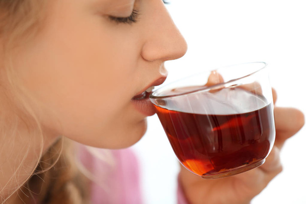 Mujer joven bebiendo té sobre fondo claro
 - Foto, imagen