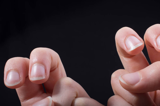 Deux doigts d'une main d'enfant en partie vus en fond noir - Photo, image