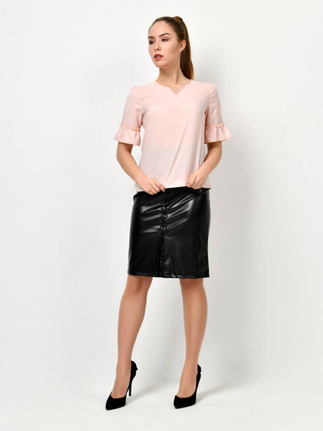 Young beautiful woman posing in new casual office cloth and leather skirt on a white - Valokuva, kuva
