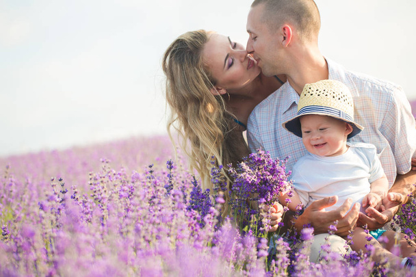 Young family in a lavender field - Foto, afbeelding