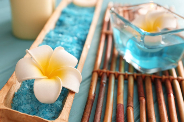 Bandeja de bambu com flor e sal marinho para tratamento de spa na mesa
 - Foto, Imagem