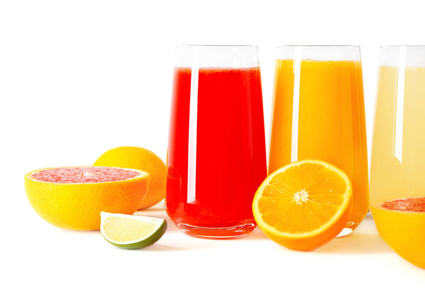 Different fresh juices in glasses and cut fruits on white background - Photo, Image