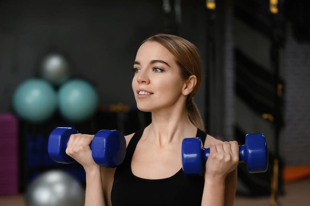 Young woman training with dumbbells in modern gym - Fotografie, Obrázek