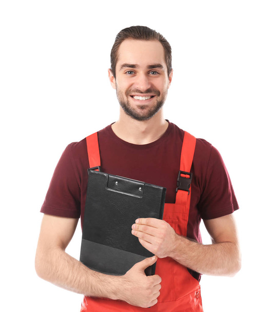 Young car mechanic with clipboard on white background - Фото, изображение